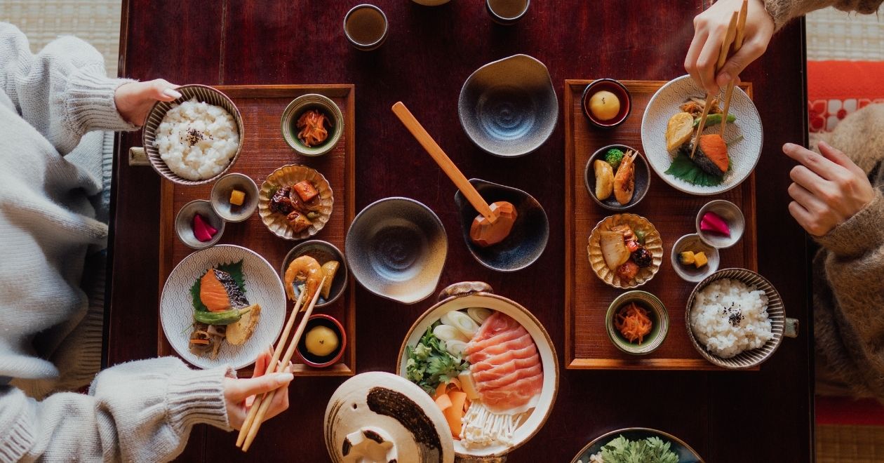Prato com arroz japonês e sashimi, incluindo fatias de peixe cru .