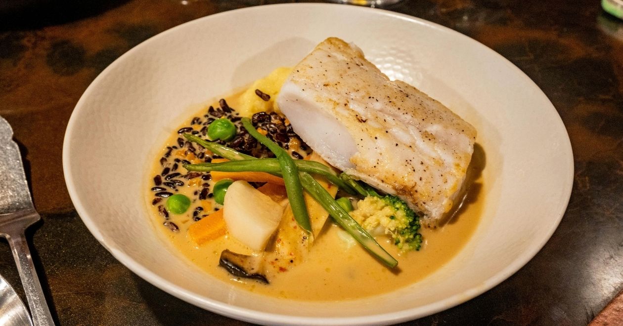 Prato de bacalhau com batatas, cebolas e azeitonas, típico da culinária portuguesa.