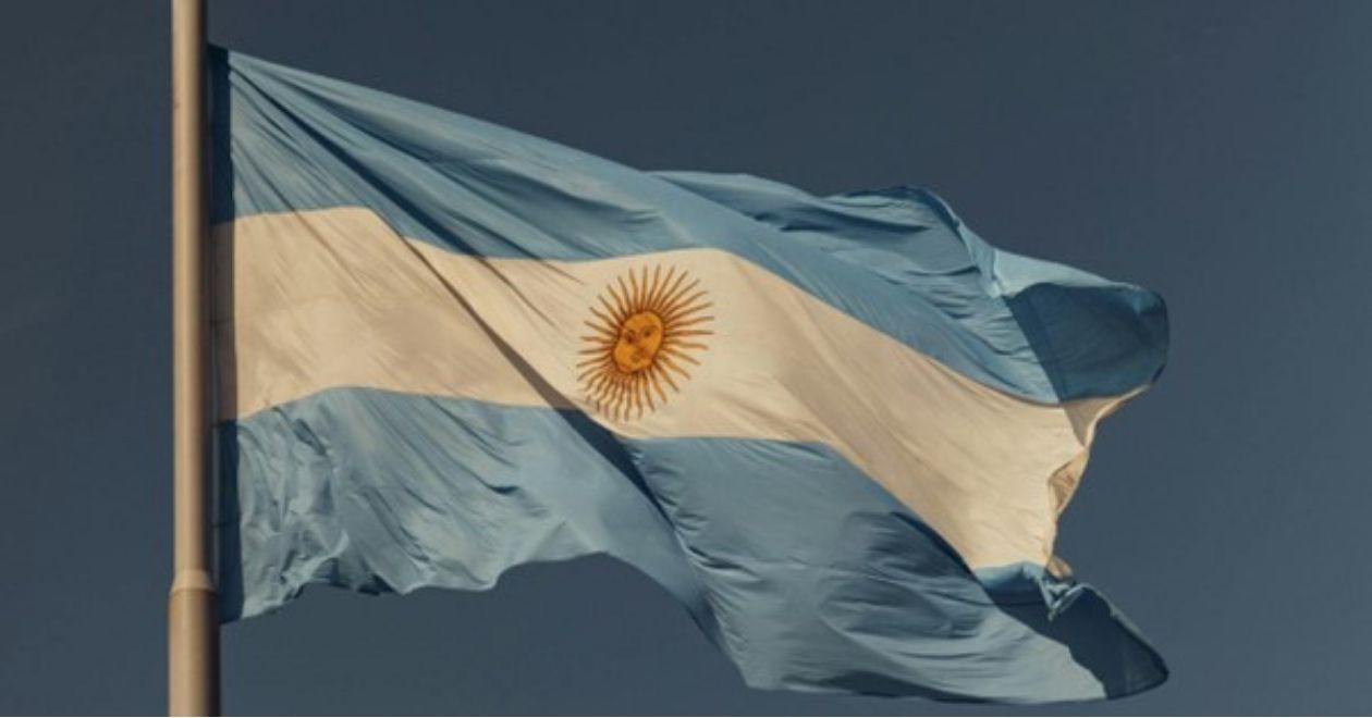 A bandeira da Argentina tem três faixas horizontais: azul celeste em cima e embaixo, e branca no meio com um sol amarelo no centro.