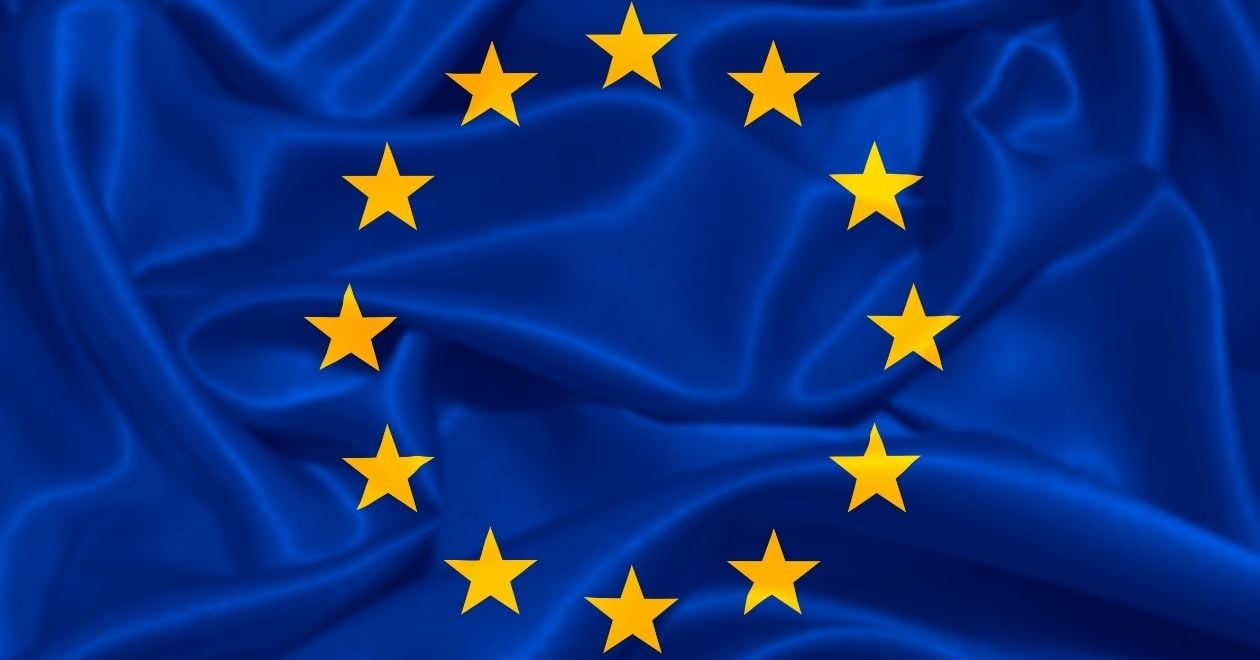 A bandeira tem um fundo azul, semelhante ao da União Europeia, com um círculo de estrelas douradas no centro. As estrelas representam os países membros do tratado, simbolizando unidade e colaboração. O azul transmite a ideia de paz e estabilidade.